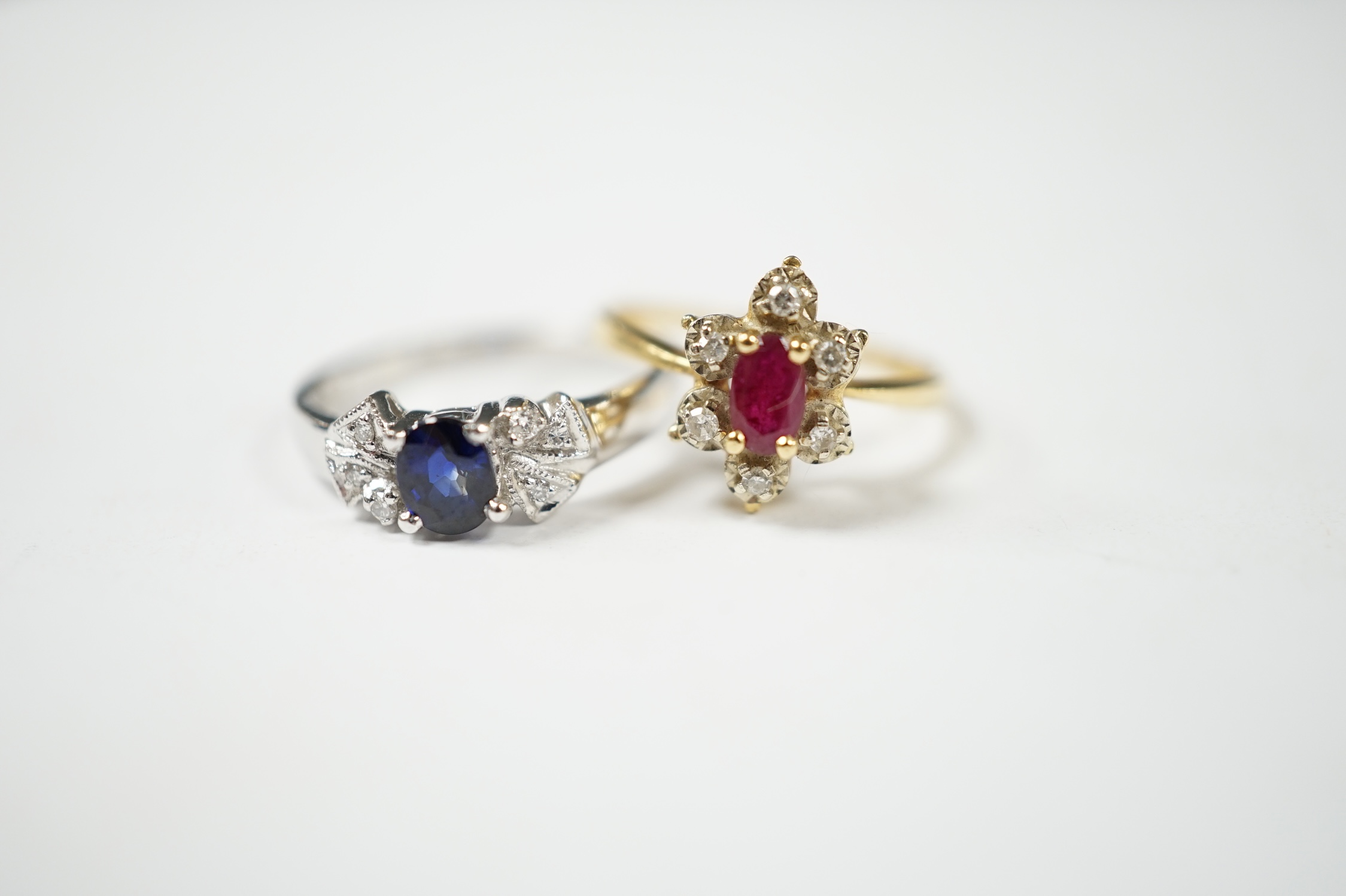A French 18k, ruby and diamond set flower head cluster ring, size J and an 18k white metal, sapphire and diamond chip set ring, gross weight 4.8 grams. Condition - fair